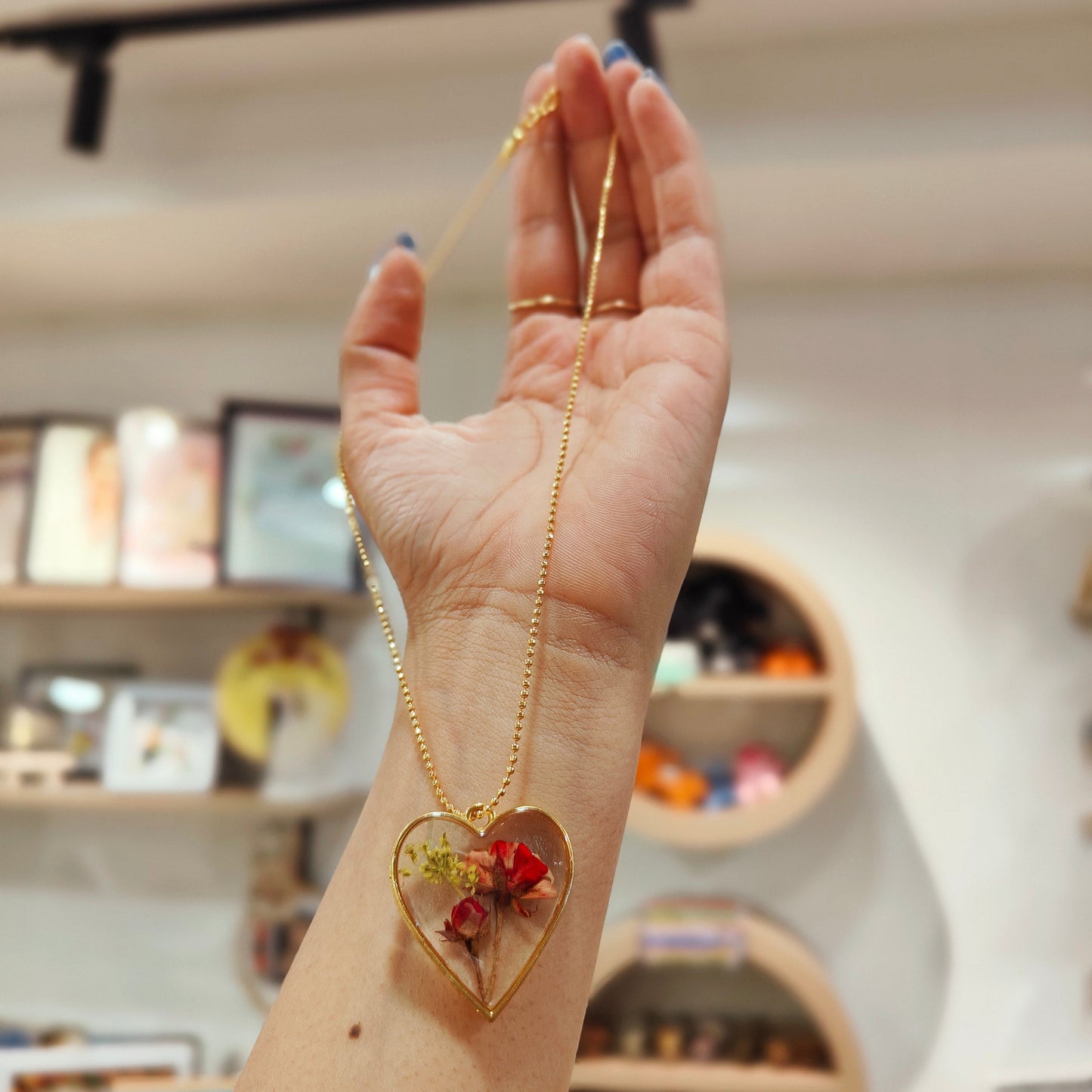 Red pressed rose buds & gold flake inside gold open heart-shaped matte pendant, 16" gold-plated chain included