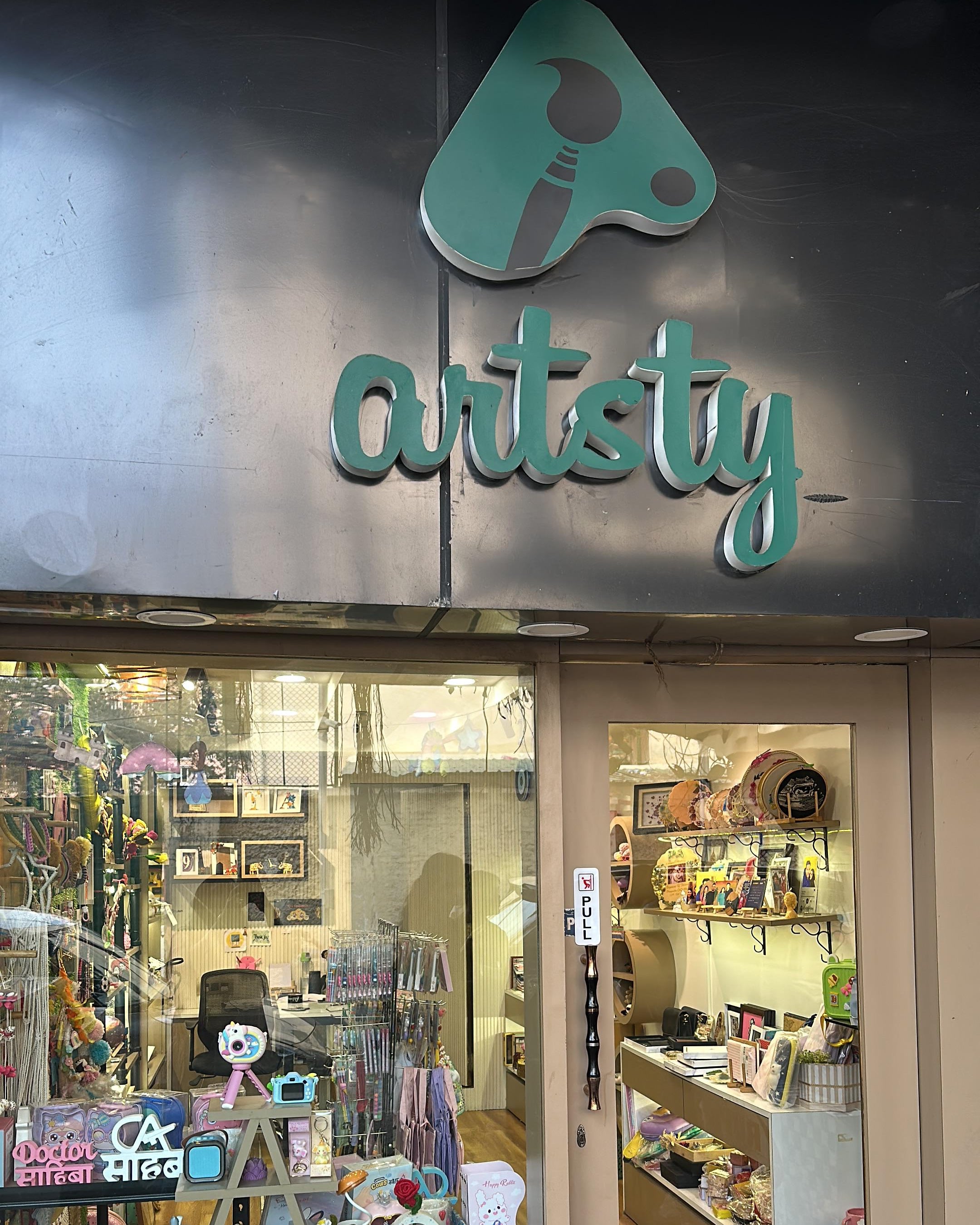 Storefront with 'artsty' sign and display of products inside