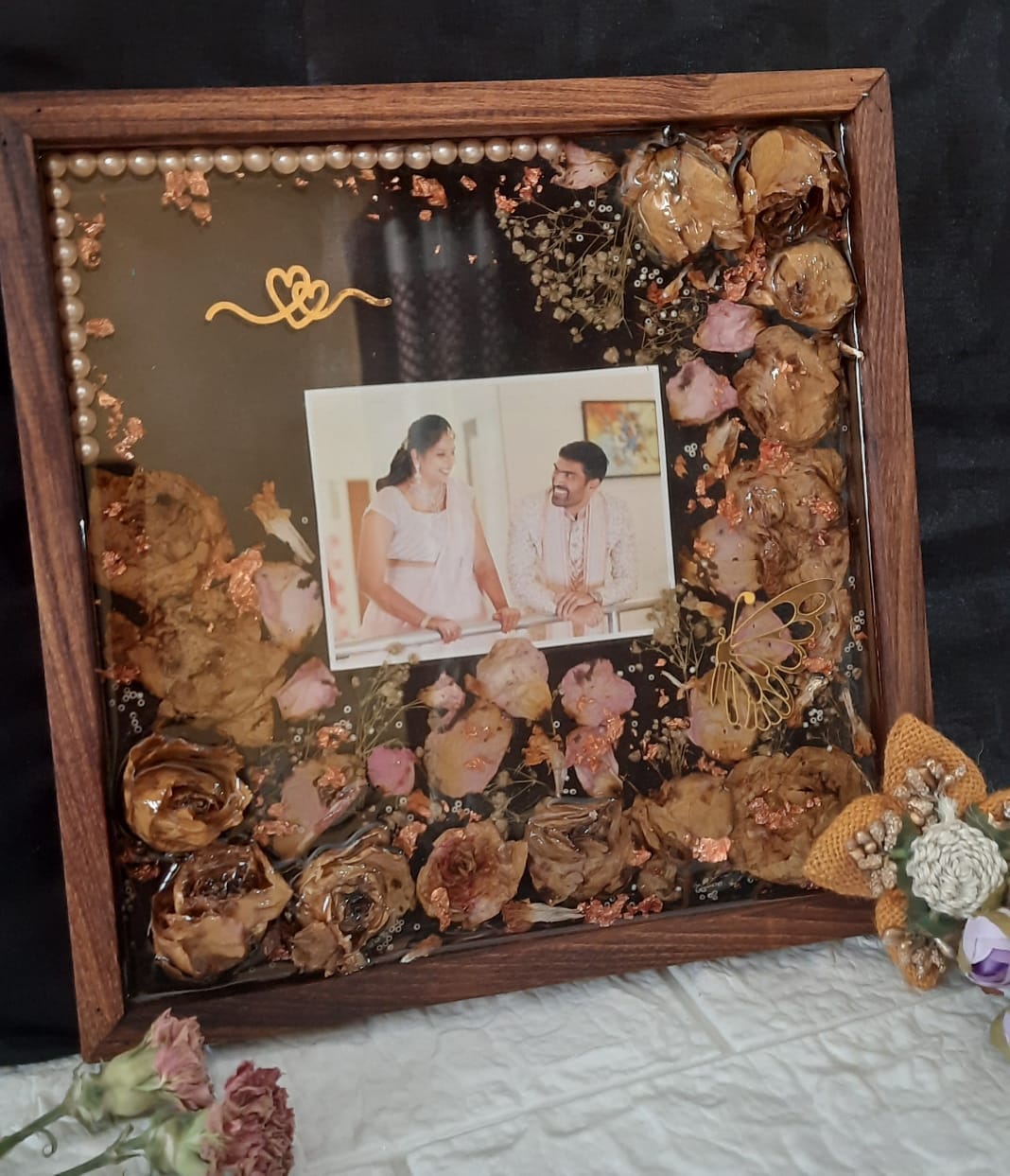 Eternal Bonds: Preserved Varmala Flowers in a Timeless Wooden Frame with Couples' Pictures