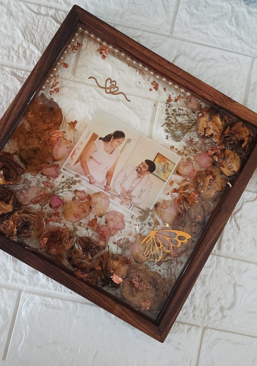 Eternal Bonds: Preserved Varmala Flowers in a Timeless Wooden Frame with Couples' Pictures